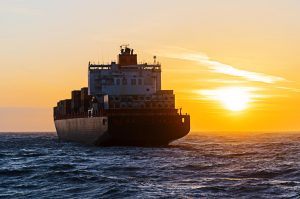 Container ship heading towards sunset on the north sea in Germany.